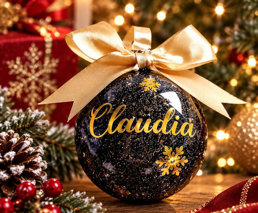 Black personalised Christmas bauble with gold name lettering, gold snowflakes and gold ribbon bow